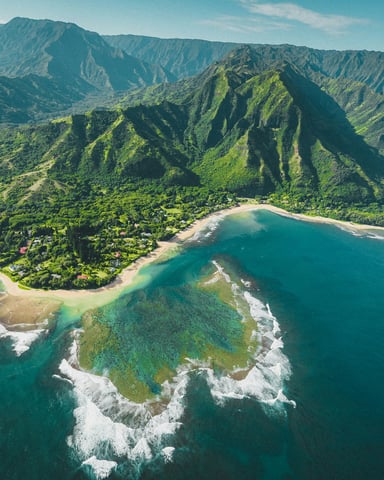 Aerial view of Na Pali coastline with turquoise water and dramatic green cliffs, Kauai